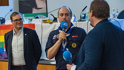 Eine Person mit Mikrofon in der Hand bei der Verabschiedung