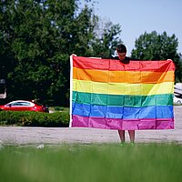 Eine Person mit Regenbogenflagge.