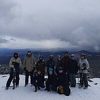 Die Sch&uuml;ler stehen mit Skiausr&uuml;stung auf der Piste.