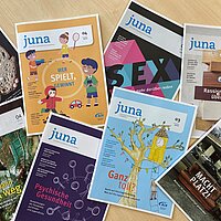 Mehrere juna-Zeitschriften liegen kreuz und quer &uuml;bereinander.