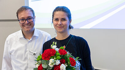 Zwei Personen, eine mit Blumenstrau&szlig;