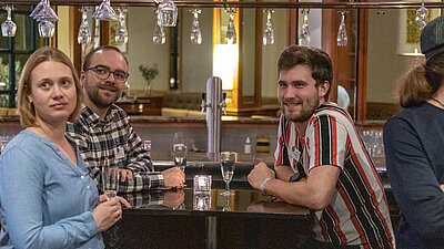 Drei Personen warten auf den Einlass zum Festabend