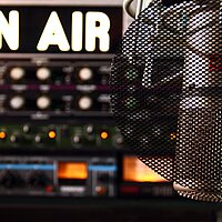 Ein Radiomikrofon in Nahaufnahme, im Hintergrund ein Radiostudio. Link zu www.jugendradioszene.de/