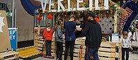 Junge Menschen stehen an Verleihschalter des Radsportfestivals "RampaZamba" an