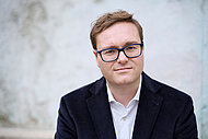 Portr&auml;tfoto von Philipp Seitz im dunkelblauen Jackett und wei&szlig;en Hemd