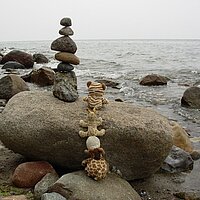 Steinturm auf einem gro&szlig;en Stein vor dem Meer