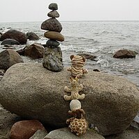 Steinturm auf einem gro&szlig;en Stein vor dem Meer